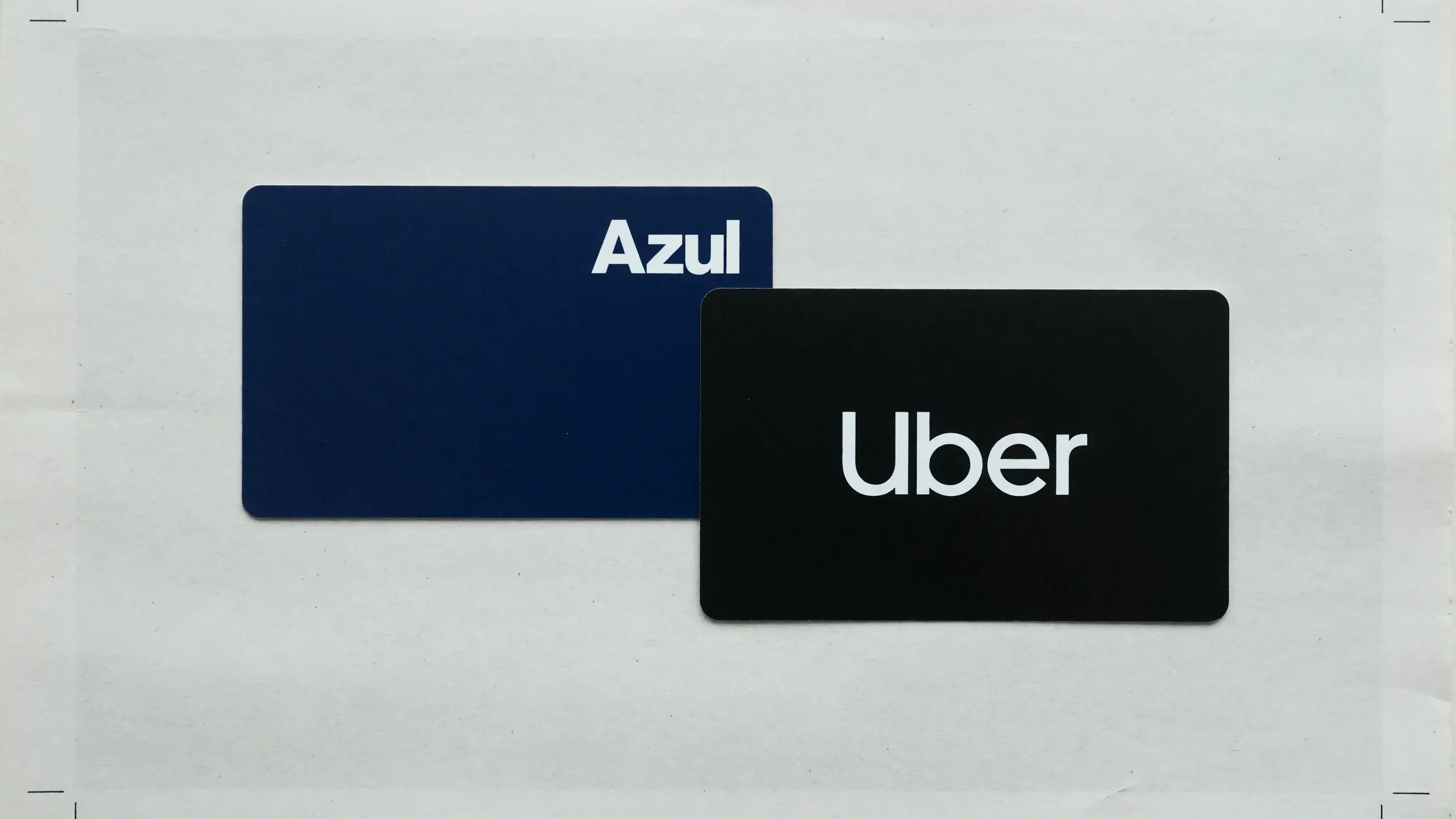 Ilustração do resgate no Shopping Azul Fidelidade: um voucher digital da Uber ao lado do cartão de pontos do Azul Fidelidade, nas cores azuis do programa da Azul e no preto da Uber.