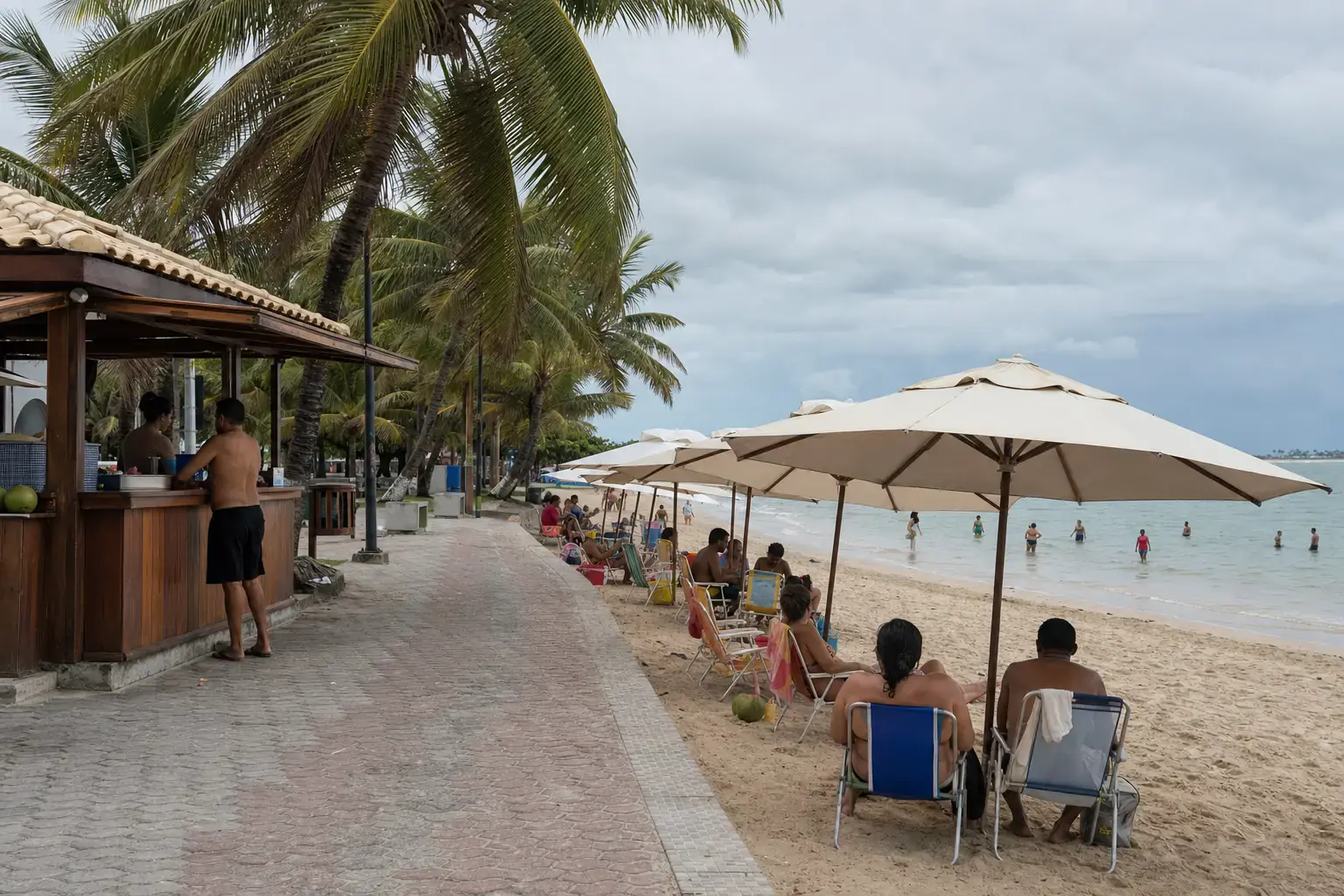 praia do Nordeste em dia comum, com o quiosque aberto, os guarda-sóis armados sobre a areia e banhistas no raso